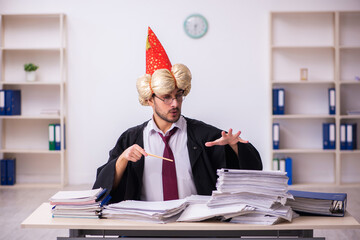 Funny young male employee magician and too much work in the office