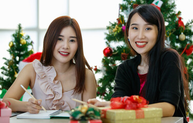 Happy Asian women making Christmas wishes