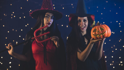 Witches with Jack o Lantern and devil trident on Halloween party