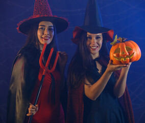 Witches with Jack o Lantern and devil trident on Halloween party