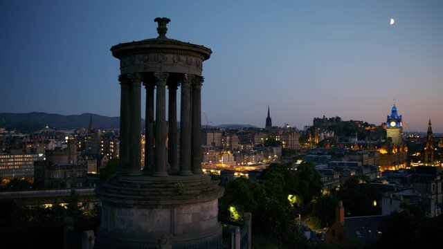 Twilight panorama of Edinburgh, Scotland, UK, featuring the Dugald Stewart Monument in Calton Hill, the Old Town and New Town. The city of Edinburgh is a UNESCO World Heritage Site
