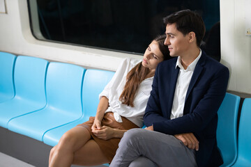 young woman sleeping on the man shoulder in the subway train