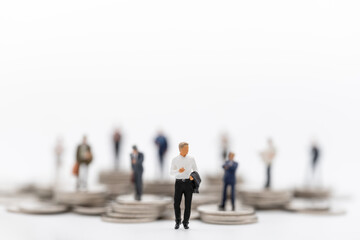 Business, Money Investment and Planning Concept. Group of Businessman miniature figure people figure standing with stack of silver coins on white background.