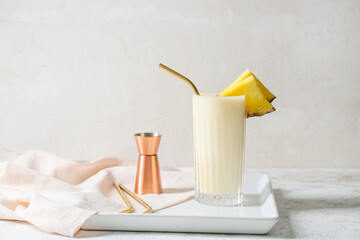 Glass with tasty Pina Colada cocktail on light background