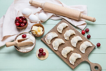 Composition with raw cherry dumplings on color wooden background