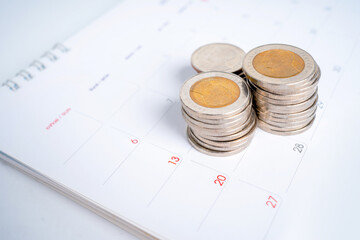 Pile of Thai baht coins on the calendar. Finance and Banking Concepts.