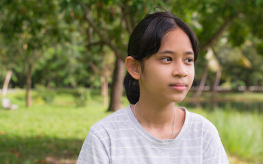 Portrait Asian pretty female teenager in casual dress looking at the view while standing in the park. People lifestyle. Generation z. Simple living. - 447825880