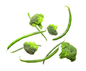 Flying green beans and broccoli on white background