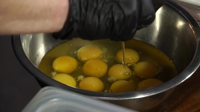 Cook smashes chicken eggs into a container