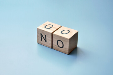 Wooden cubes with the inscription: go! and no!The choice between moving and stopping in life