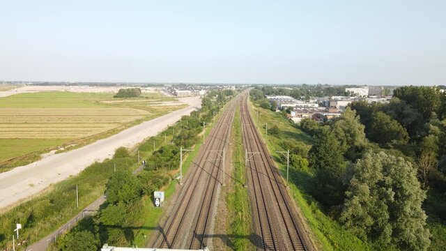 Train track passenger train aerial view of public transport infrastructure in a typical dutch landscape.