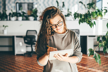 Freelancer woman using laptop at comfortable office, green co-working modern workplace