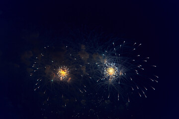 Blurred multicolored fireworks lights against the dark night sky