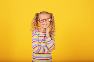 a beautiful blonde girl with ponytails and a multi-colored T-shirt with red-rimmed glasses