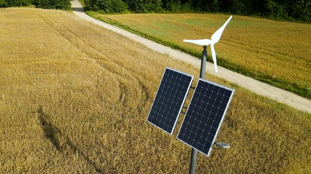 Aerial view of small solar panels and wind turbine powering light pole in the agricatural field in Czeczewo -
Village in Poland
