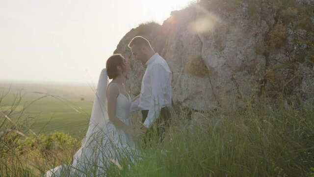 Side view of young couple that smiles and huggs