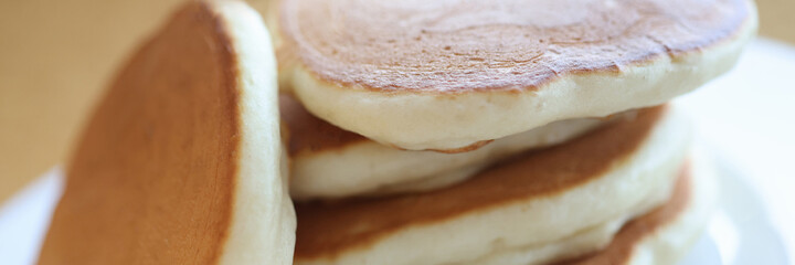 Portion of cooked flour pancakes lying on white plate closeup