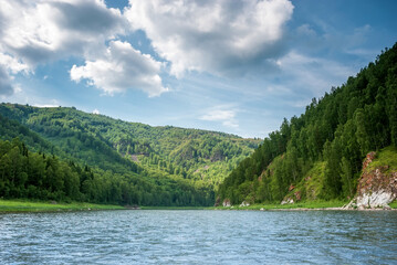 Naklejka na ściany i meble Landscape of Siberia. Kiya River, mountain banks and green forests in the Kemerovo region. Daytime landscape with blue skies and clouds.