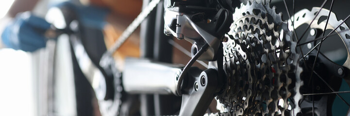 Master repairman repairing bicycle in workshop closeup