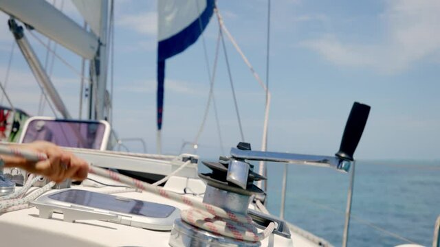 Close Up of Sailman Hands Unwinding Rope From Winch of Sailboat on Sunny Tropic Day, Slow Motion Full Frame