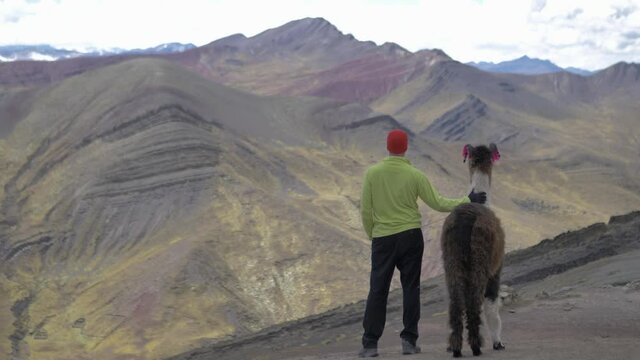 madel model with llama looking at mountains in the andes of cusco peru, rainbow mountains of seven colors