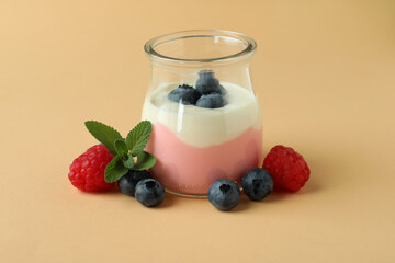 Concept of tasty breakfast with yogurt on beige background