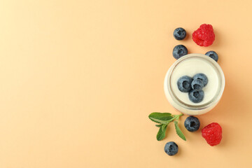 Concept of tasty breakfast with yogurt on beige background