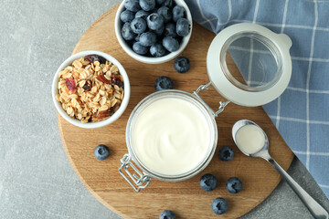 Concept of tasty breakfast with yogurt on gray textured table
