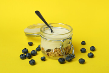 Concept of tasty breakfast with yogurt on yellow background