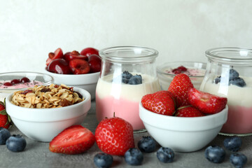 Concept of tasty breakfast with yogurt on gray textured table