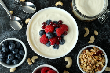Concept of tasty breakfast with yogurt on black smokey table