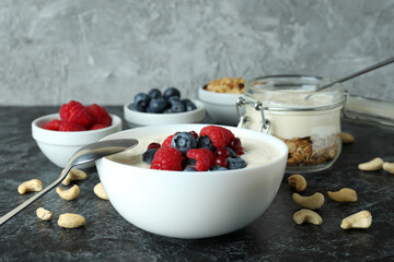 Concept of tasty breakfast with yogurt on black smokey table