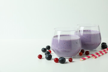 Glasses of smoothie and ingredients on white background