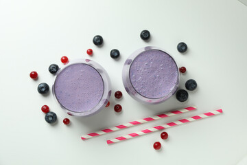 Glasses of smoothie and ingredients on white background