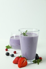 Glasses of smoothie and ingredients on white background