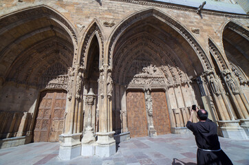 Friar taking picture to Leon Cathedral, Spain