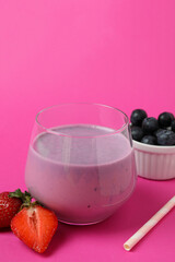 Fresh smoothie, ingredients and straw on pink background