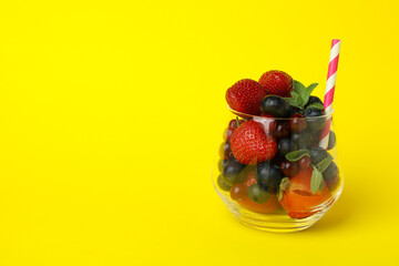 Glass with smoothie ingredients on yellow background