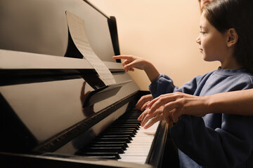 Young woman with child playing piano, closeup. Music lesson