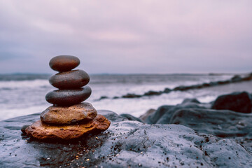 Pyramid of stones by the ocean at blue hour