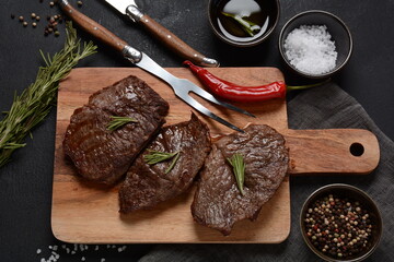 Grilled juicy beef steak with rosemary, fried meat, close-up. Top Blade steaks on wooden board