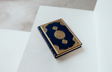 The Qur'an is the holy book in Islam on a white shelf