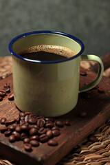 close-up of mug filled with black coffee and decorated with roasted coffee beans