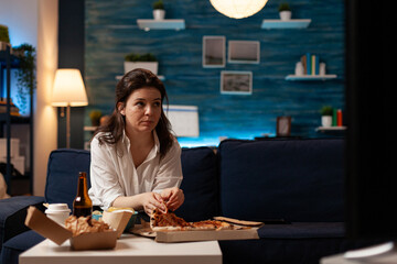 Caucasian female taking tasty delicious pizza slice eating fastfood home-delivered order while...