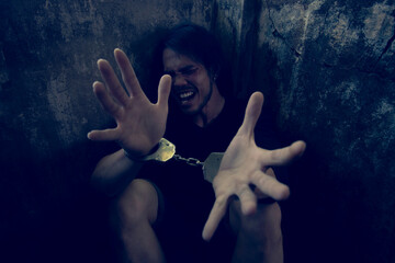 Depressed and hopeless asian man sitting alone after using drugs sitting on the floor. Drugs addiction and withdrawal symptoms concept.