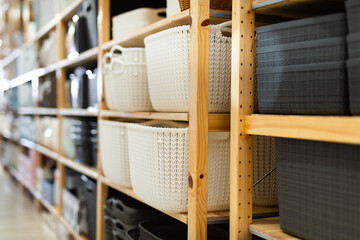Closeup of decorative plastic storage boxes displayed on shelves for sale in home furnishings store