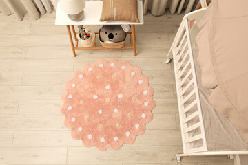 Baby room interior with modern furniture and soft rug, above view