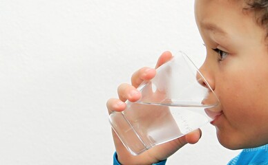 boy drinking water from a glass with white background stock photo