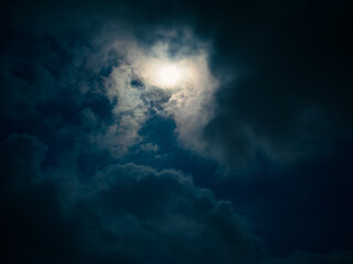 Naklejka na ściany i meble Full moon among clouds in the night sky.