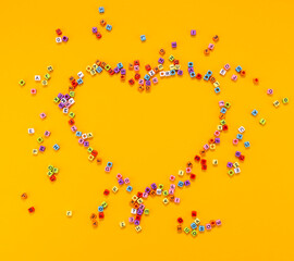 heart shaped multicolored cubes with letters on a yellow background